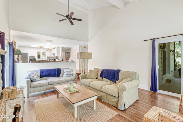 living room with a healthy amount of sunlight, light hardwood / wood-style floors, and beamed ceiling