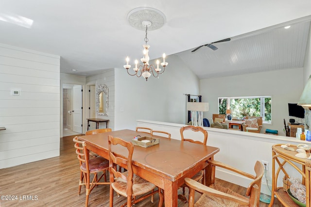 dining area featuring lofted ceiling, a chandelier, and light hardwood / wood-style flooring