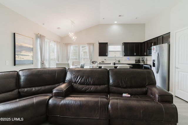 173 Okatie Park Cir E, Ridgeland, SC 29936 - living room featuring a chandelier, healthy amount of natural light, light wood finished floors, and high vaulted ceiling