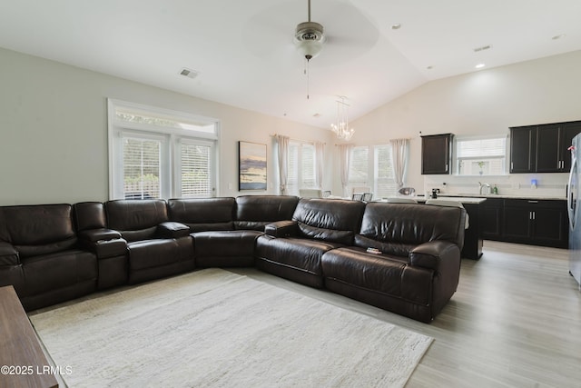 173 Okatie Park Cir E, Ridgeland, SC 29936 - living room featuring a ceiling fan, a chandelier, light wood finished floors, healthy amount of natural light, and vaulted ceiling