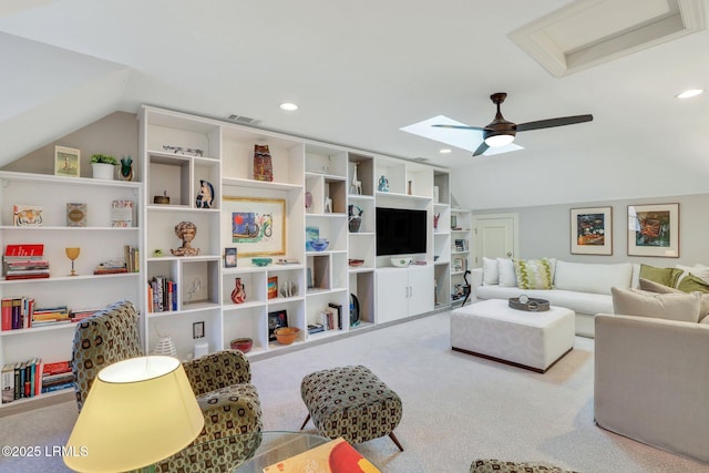 carpeted living room with lofted ceiling with skylight and ceiling fan