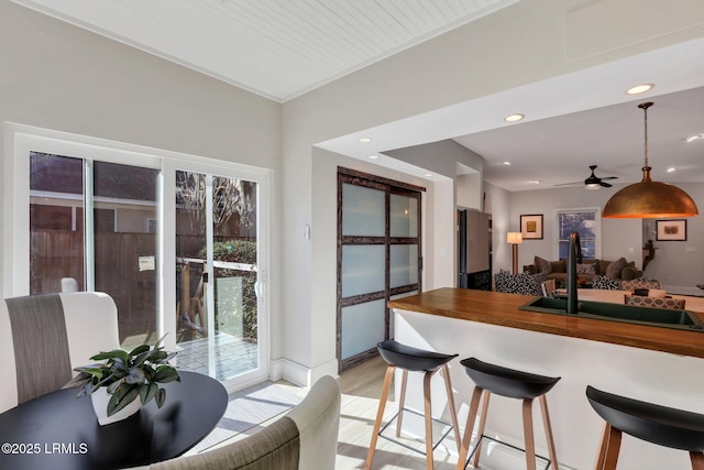 kitchen featuring sink, wooden counters, fridge, wooden ceiling, and light wood-type flooring