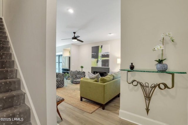 living room with wood-type flooring and ceiling fan