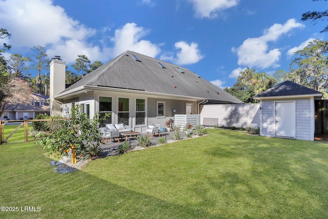 rear view of property featuring a storage unit, a patio, and a lawn