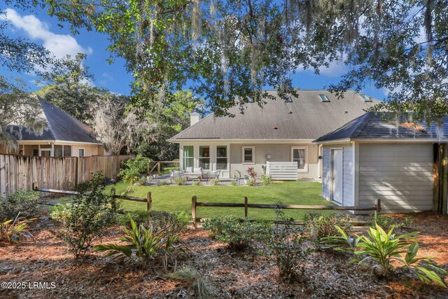 rear view of property with a yard, an outdoor structure, and a patio