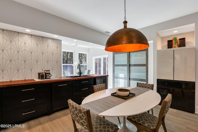 dining area featuring sink and light wood-type flooring