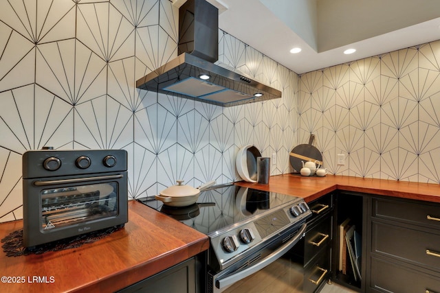 kitchen featuring wood counters, island range hood, tasteful backsplash, and stainless steel range with electric cooktop