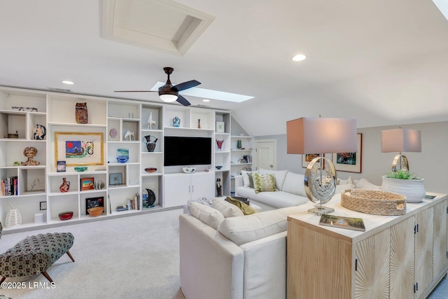 carpeted living room with lofted ceiling with skylight and ceiling fan