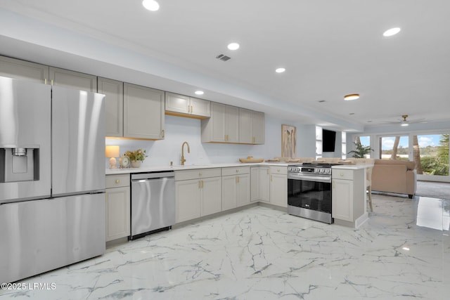 kitchen featuring open floor plan, stainless steel appliances, gray cabinets, and recessed lighting