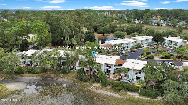 drone / aerial view featuring a forest view and a residential view