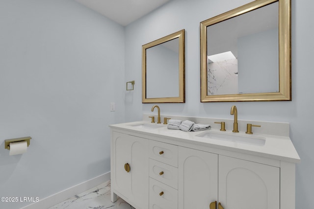 bathroom featuring marble finish floor, double vanity, a sink, and baseboards