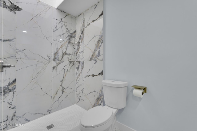 bathroom with a marble finish shower and toilet