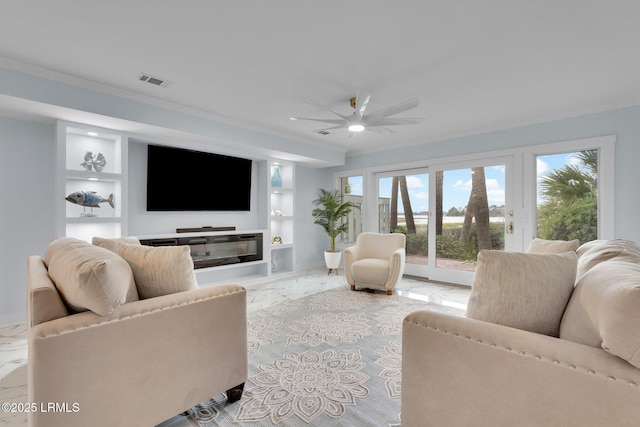 living area with ceiling fan, built in shelves, visible vents, and ornamental molding