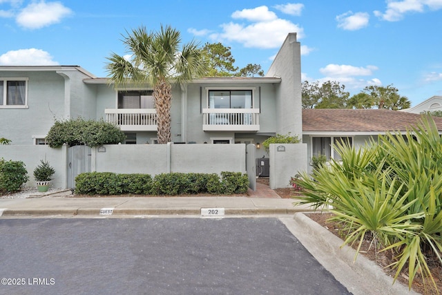 townhome / multi-family property featuring a fenced front yard and stucco siding