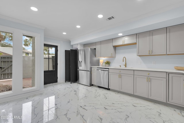 kitchen with stainless steel appliances, a sink, and gray cabinetry