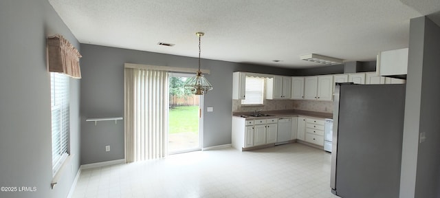15 Grackle Ln, Beaufort, SC 29906 - kitchen featuring white appliances, light flooring, a textured ceiling, white cabinets, and hanging light fixtures