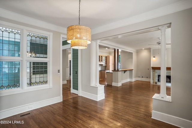 interior space with dark hardwood / wood-style flooring, crown molding, ceiling fan, and ornate columns