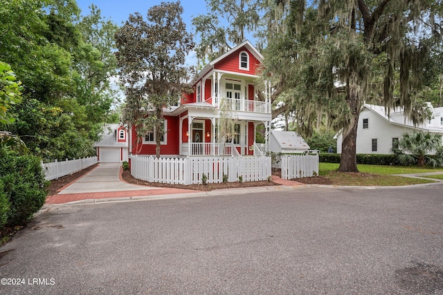 victorian house with a garage, a balcony, and covered porch