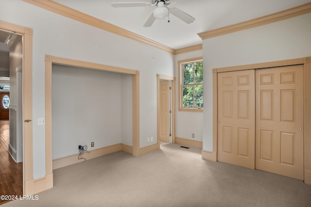 unfurnished bedroom featuring crown molding, ceiling fan, carpet flooring, and a closet