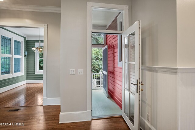 entryway featuring crown molding, dark hardwood / wood-style floors, and a notable chandelier