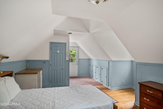 bedroom featuring lofted ceiling and light hardwood / wood-style flooring