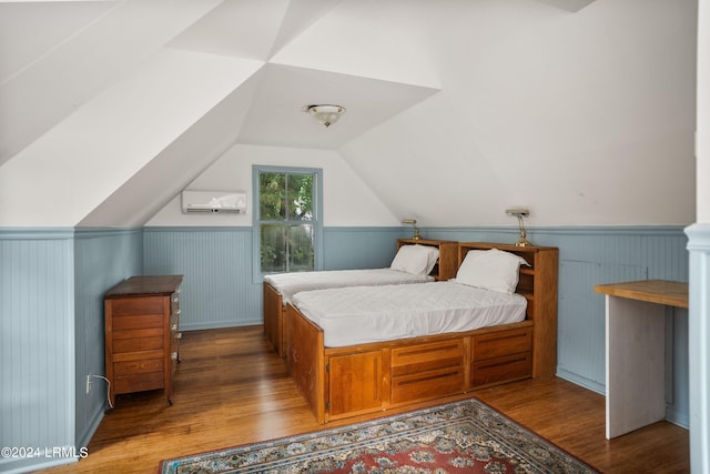 bedroom featuring lofted ceiling, hardwood / wood-style flooring, and an AC wall unit