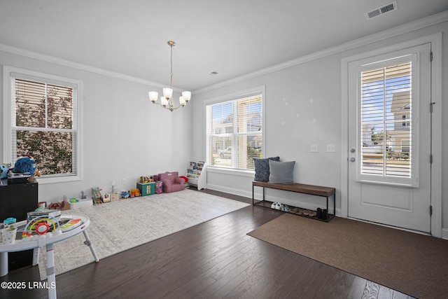 recreation room with ornamental molding, wood finished floors, visible vents, and a notable chandelier