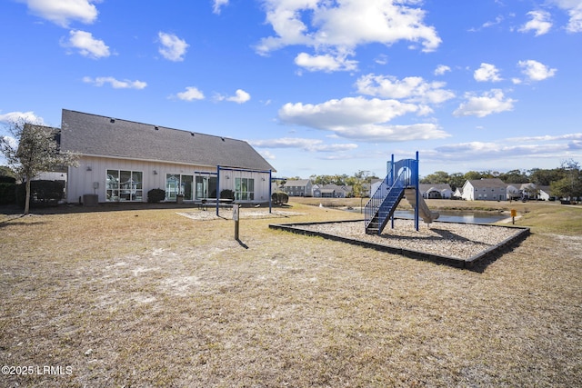 exterior space featuring a shingled roof and playground community