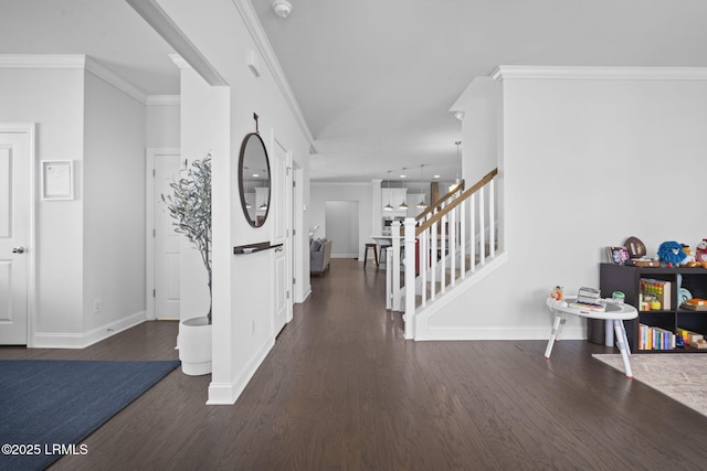 foyer featuring wood finished floors, crown molding, and stairs