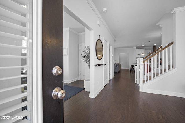 foyer featuring baseboards, dark wood-type flooring, stairway, and crown molding