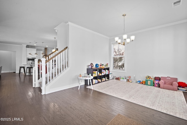 recreation room featuring a notable chandelier, visible vents, baseboards, dark wood-style floors, and crown molding