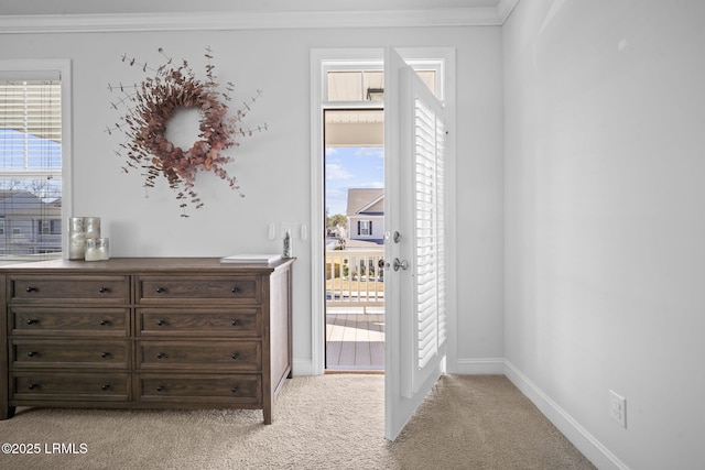 interior space with carpet floors, ornamental molding, and baseboards