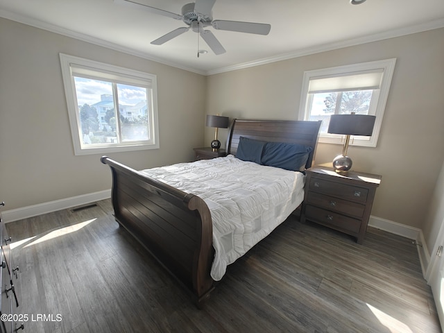 bedroom featuring ceiling fan, visible vents, baseboards, dark wood finished floors, and crown molding