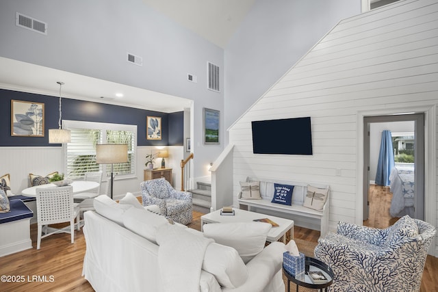 living area featuring stairway, wood finished floors, and visible vents