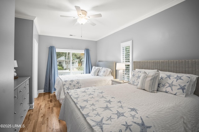 bedroom featuring a ceiling fan, baseboards, visible vents, light wood-style floors, and ornamental molding