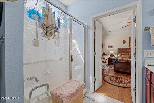 bathroom with an enclosed shower, vanity, hardwood / wood-style flooring, and ceiling fan