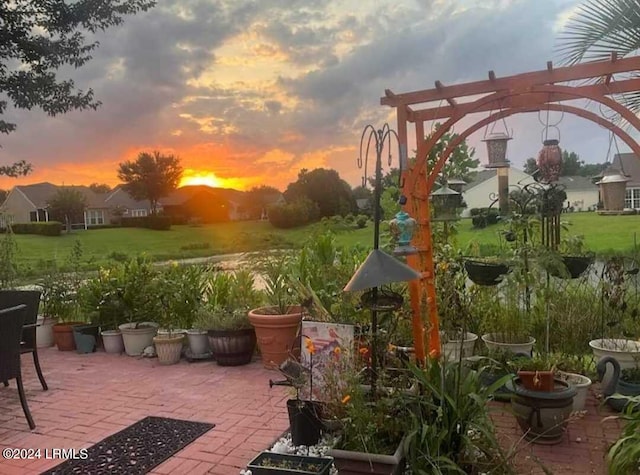 patio terrace at dusk with a yard and a pergola