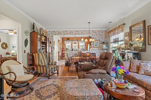 living room with crown molding, ceiling fan with notable chandelier, and hardwood / wood-style floors