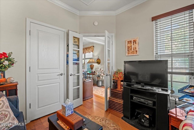 living room with ornamental molding, light hardwood / wood-style floors, and french doors