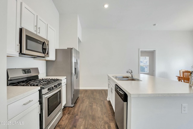 kitchen featuring stainless steel appliances, light countertops, white cabinetry, a sink, and an island with sink