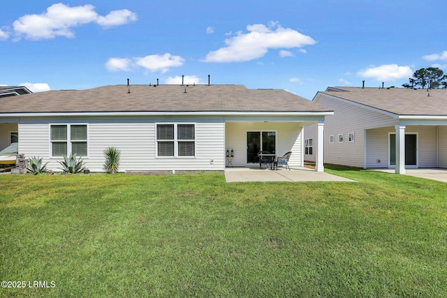 rear view of house with a lawn and a patio