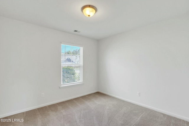 carpeted spare room featuring baseboards and visible vents