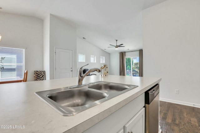 kitchen featuring vaulted ceiling, light countertops, stainless steel dishwasher, and a sink