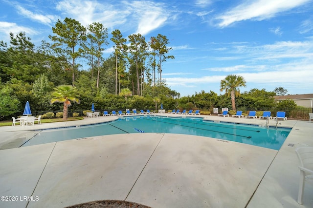 pool with a patio area and fence