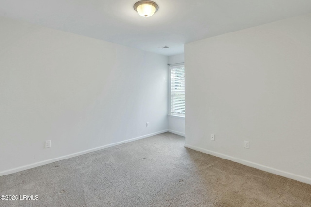 empty room with baseboards and light colored carpet