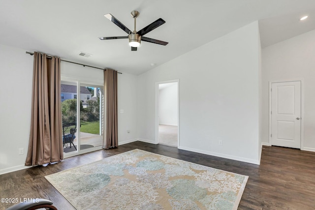 empty room featuring lofted ceiling, baseboards, visible vents, and dark wood finished floors