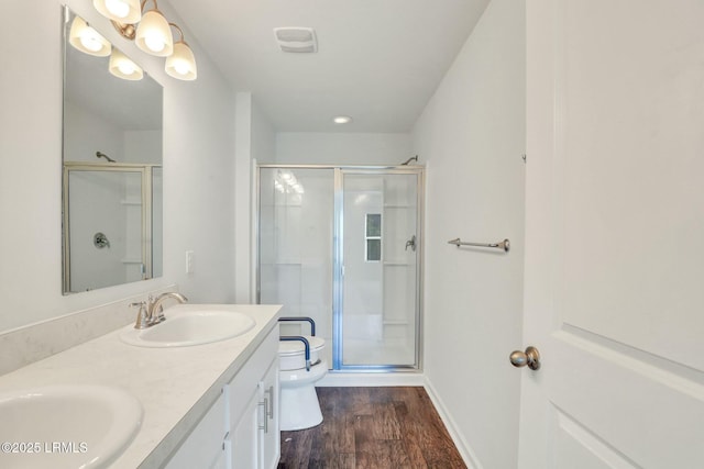 full bathroom featuring toilet, a stall shower, a sink, and wood finished floors