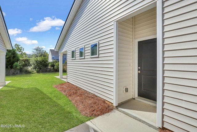 doorway to property with a lawn