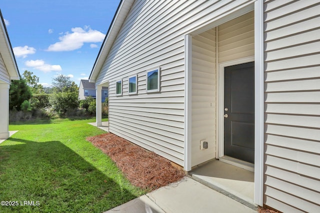 view of exterior entry featuring a lawn