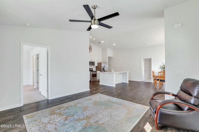 interior space featuring a ceiling fan, lofted ceiling, dark wood-style flooring, and baseboards